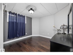 Unfurnished dining area with a drop ceiling and dark wood finished floors - 