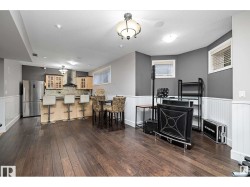 Dining space featuring wainscoting and dark wood-type flooring - 