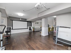 Cinema with dark wood-style floors, arched walkways, and a textured ceiling - 