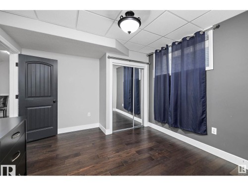 Unfurnished dining area featuring dark wood-style floors and a drop ceiling - 9544 154 Street, Edmonton, AB 