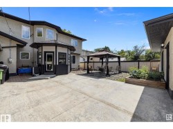 Back of property featuring a gazebo, a patio, a fenced backyard, and stucco siding - 