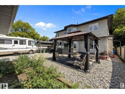 Rear view of house with a gazebo, a patio, and stucco siding - 