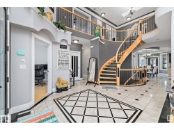 Entryway with suspended lighting, inlaid floor details, a high ceiling, and arched walkways - 