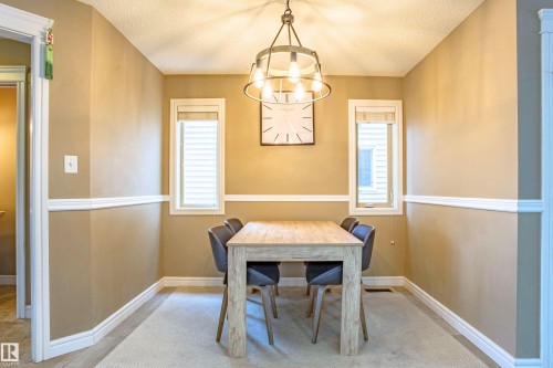 Dining room with a textured ceiling and suspended lighting - 2224 Austin Way, Edmonton, AB - Indoor Photo Showing Dining Room