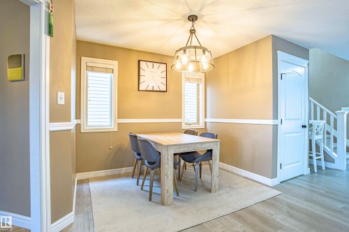 Dining area featuring light wood finished floors and a textured ceiling - 2224 Austin Way, Edmonton, AB - Indoor Photo Showing Dining Room