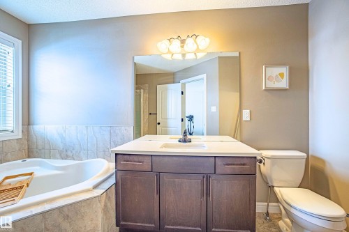 Bathroom featuring vanity, a garden tub, a stall shower, and a textured ceiling - 2224 Austin Way, Edmonton, AB - Indoor Photo Showing Bathroom