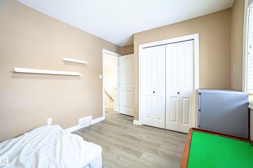 Bedroom with light wood-style flooring, a closet, and a textured ceiling - 2224 Austin Way, Edmonton, AB - Indoor Photo Showing Bedroom