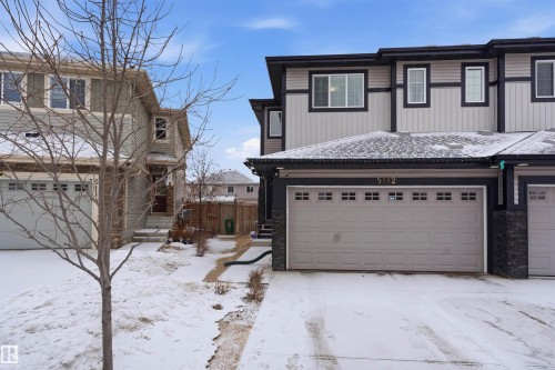 Traditional-style home featuring concrete driveway, stone siding, and a garage - 5112 Andison Close, Edmonton, AB - Outdoor