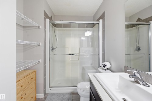 Bathroom with a stall shower, vanity, and a textured ceiling - 5112 Andison Close, Edmonton, AB - Indoor Photo Showing Bathroom