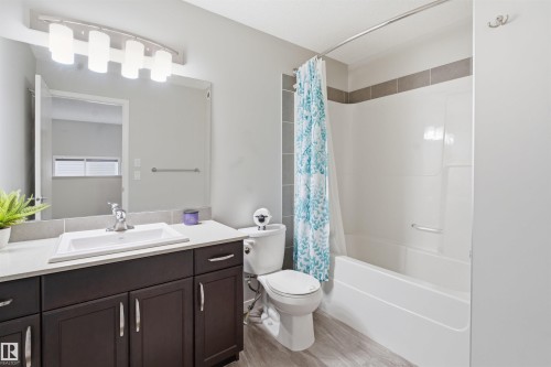 Bathroom featuring vanity, shower / tub combo with curtain, and light wood-style floors - 5112 Andison Close, Edmonton, AB - Indoor Photo Showing Bathroom