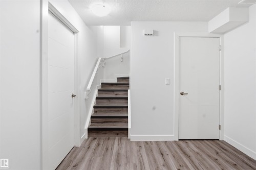 Stairs featuring a textured ceiling and wood finished floors - 5112 Andison Close, Edmonton, AB - Indoor Photo Showing Other Room