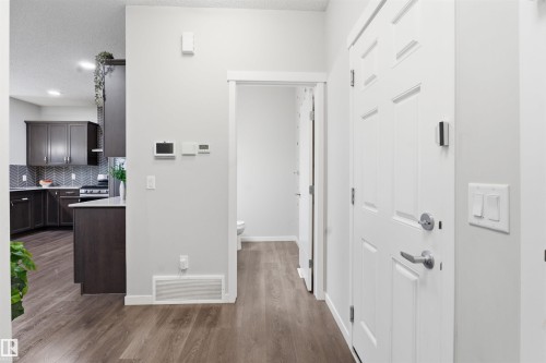 Hallway with dark wood-style floors and a textured ceiling - 5112 Andison Close, Edmonton, AB - Indoor Photo Showing Other Room