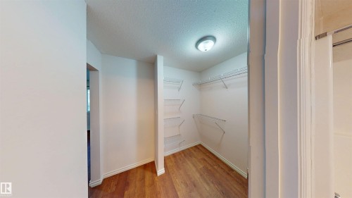 Walk in closet with light wood-type flooring - 115 9938 104 St, Edmonton, AB - Indoor Photo Showing Other Room