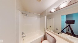 Full bath featuring a textured ceiling, vanity, and shower / bath combination - 