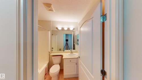 Full bath featuring vanity, a textured ceiling, and shower / washtub combination - 115 9938 104 St, Edmonton, AB - Indoor Photo Showing Bathroom