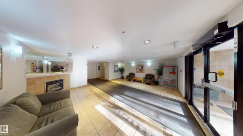 Workout area with recessed lighting and a tiled fireplace - 115 9938 104 St, Edmonton, AB - Indoor With Fireplace