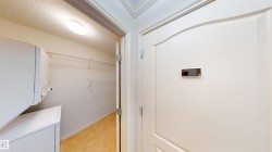 Laundry area featuring stacked washer / drying machine, a textured ceiling, and light tile patterned floors - 