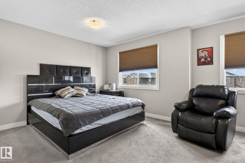 Carpeted bedroom featuring a textured ceiling and baseboards - 21867 80 Avenue, Edmonton, AB - Indoor Photo Showing Bedroom