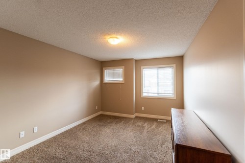 Unfurnished room with dark colored carpet and a textured ceiling - 1118 162 Street, Edmonton, AB - Indoor Photo Showing Other Room