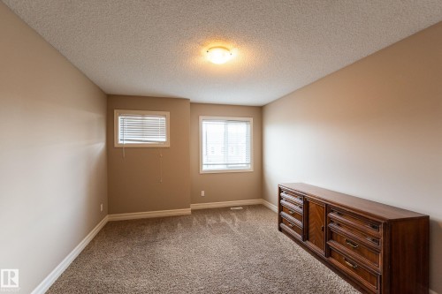 Empty room featuring dark colored carpet and a textured ceiling - 1118 162 Street, Edmonton, AB - Indoor Photo Showing Other Room