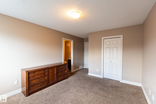 Unfurnished bedroom with carpet, a textured ceiling, and a closet - 1118 162 Street, Edmonton, AB - Indoor