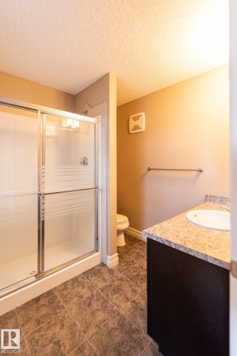 Full bathroom featuring vanity, a shower stall, and a textured ceiling - 1118 162 Street, Edmonton, AB - Indoor Photo Showing Bathroom