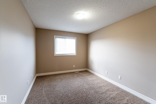 Unfurnished room featuring light colored carpet and a textured ceiling - 1118 162 Street, Edmonton, AB - Indoor Photo Showing Other Room