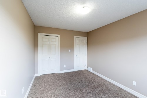 Unfurnished bedroom featuring carpet floors, a textured ceiling, and a closet - 1118 162 Street, Edmonton, AB - Indoor Photo Showing Other Room