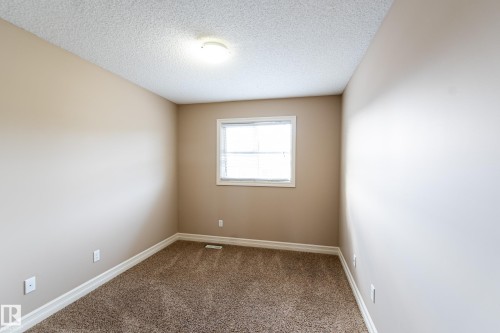Carpeted empty room with a textured ceiling and baseboards - 1118 162 Street, Edmonton, AB - Indoor Photo Showing Other Room