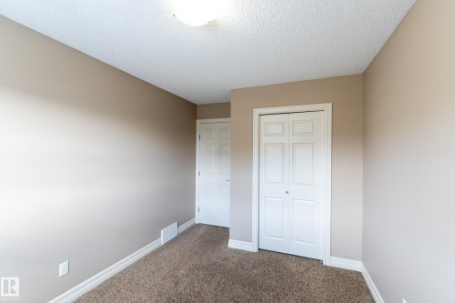 Unfurnished bedroom with carpet flooring, a closet, and a textured ceiling - 1118 162 Street, Edmonton, AB - Indoor Photo Showing Other Room