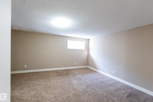 Carpeted empty room with a textured ceiling and baseboards - 1118 162 Street, Edmonton, AB - Indoor Photo Showing Other Room