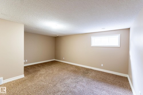 Empty room with light colored carpet and a textured ceiling - 1118 162 Street, Edmonton, AB - Indoor Photo Showing Other Room