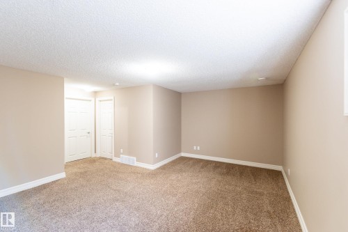 Spare room featuring light carpet and a textured ceiling - 1118 162 Street, Edmonton, AB - Indoor Photo Showing Other Room