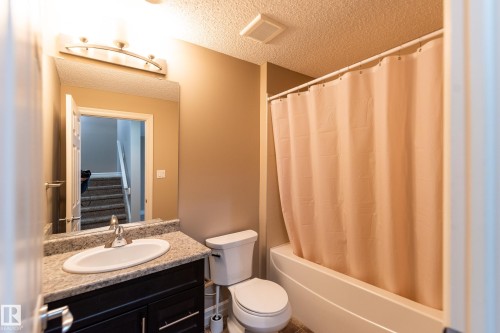 Bathroom with vanity, a textured ceiling, and shower / bathtub combination with curtain - 1118 162 Street, Edmonton, AB - Indoor Photo Showing Bathroom