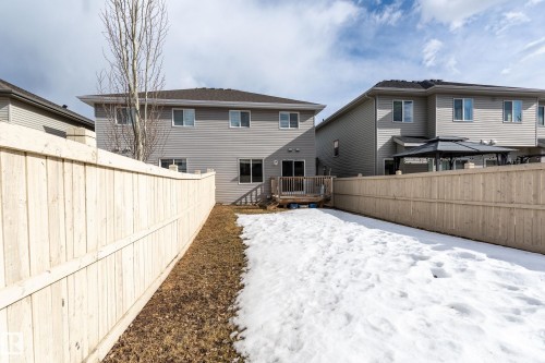 Snow covered house with a fenced backyard and a wooden deck - 1118 162 Street, Edmonton, AB - Outdoor