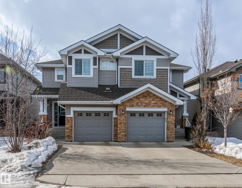 Craftsman-style home with concrete driveway, stone siding, an attached garage, and roof with shingles - 1118 162 Street, Edmonton, AB - Outdoor With Facade