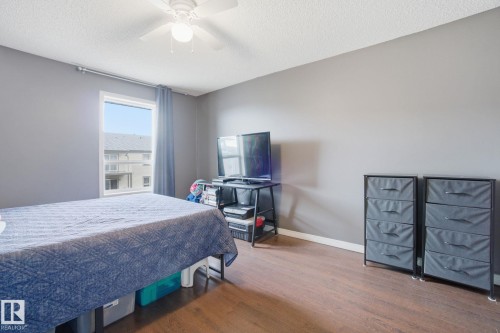 Bedroom with wood finished floors, a textured ceiling, and ceiling fan - 421 155 Edwards Drive, Edmonton, AB - Indoor Photo Showing Bedroom