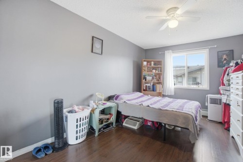 Bedroom featuring dark wood-style flooring, a ceiling fan, and a textured ceiling - 421 155 Edwards Drive, Edmonton, AB - Indoor Photo Showing Bedroom