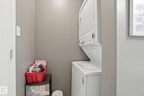 Laundry area featuring stacked washer and clothes dryer - 421 155 Edwards Drive, Edmonton, AB - Indoor Photo Showing Laundry Room