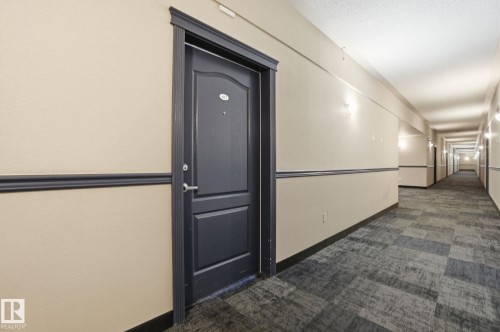 Hall with dark colored carpet and baseboards - 421 155 Edwards Drive, Edmonton, AB - Indoor Photo Showing Other Room