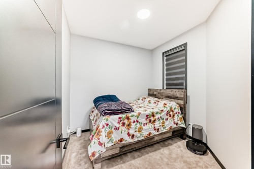 Bedroom with light carpet and baseboards - 5110 23A Avenue, Edmonton, AB - Indoor Photo Showing Bedroom