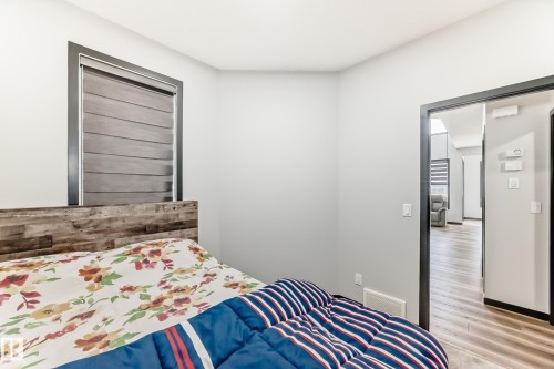 Bedroom with baseboards and light wood finished floors - 5110 23A Avenue, Edmonton, AB - Indoor Photo Showing Bedroom