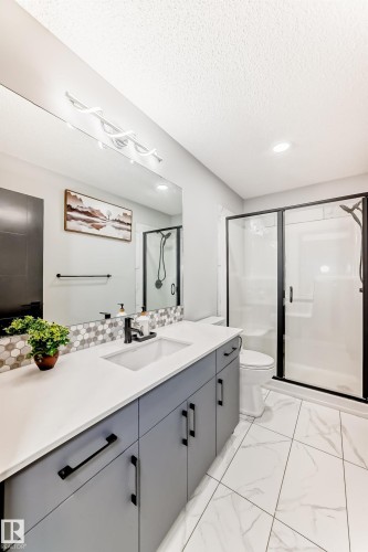 Full bath with a stall shower, vanity, recessed lighting, light marble finish flooring, and a textured ceiling - 5110 23A Avenue, Edmonton, AB - Indoor Photo Showing Bathroom