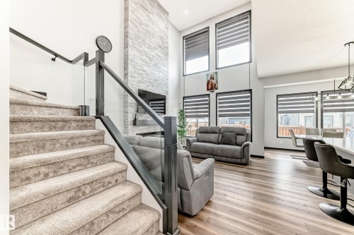 Staircase with wood finished floors, a high ceiling, plenty of natural light, and suspended lighting - 5110 23A Avenue, Edmonton, AB - Indoor Photo Showing Other Room