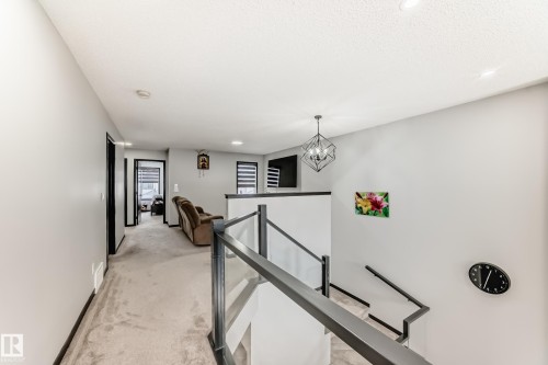Hallway featuring an upstairs landing, light colored carpet, and a chandelier - 5110 23A Avenue, Edmonton, AB - Indoor Photo Showing Other Room