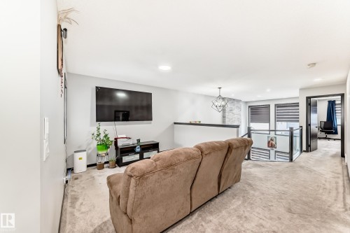 Living area with light colored carpet and suspended lighting - 5110 23A Avenue, Edmonton, AB - Indoor