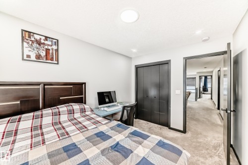 Bedroom with light carpet, a closet, and a textured ceiling - 5110 23A Avenue, Edmonton, AB - Indoor Photo Showing Bedroom