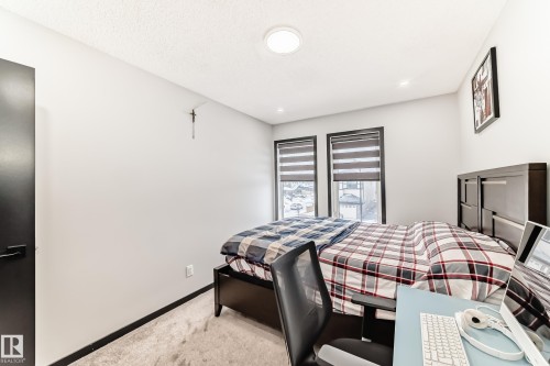 Bedroom featuring baseboards and light carpet - 5110 23A Avenue, Edmonton, AB - Indoor Photo Showing Bedroom