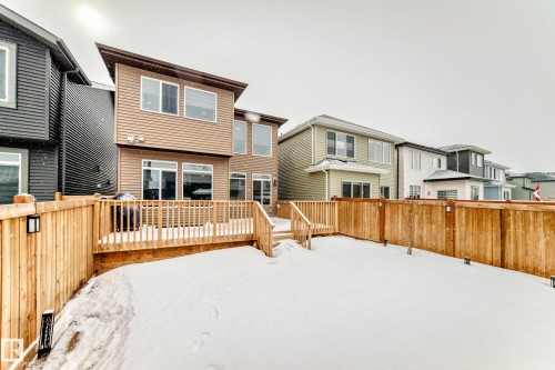 Snow covered back of property with a wooden deck - 5110 23A Avenue, Edmonton, AB - Outdoor With Exterior