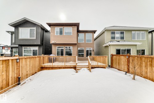 Snow covered house featuring a fenced backyard and a wooden deck - 5110 23A Avenue, Edmonton, AB - Outdoor